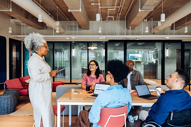 Modern software engineers collaborating in an open-plan technology office with multiple monitors displaying code, cloud dashboards, and cybersecurity analytics
